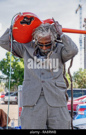 Phoenix, AZ - November 17, 2018 Street performer plays his guitar in front of the parking area at the Saturday morning Open Air market Stock Photo