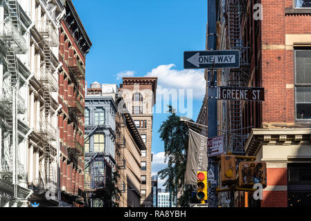 New York City, USA - June 25, 2018: Low angle view of typical buildings, traffic light and street name sign in Greene Street in  Soho Cast Iron Stock Photo