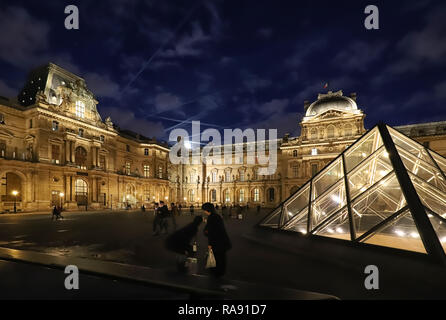 Paris, France - December 21, 2018: The Louvre Pyramid based in the main courtyard cour Napoleon of the Louvre Palace in Paris. It serves as the main e