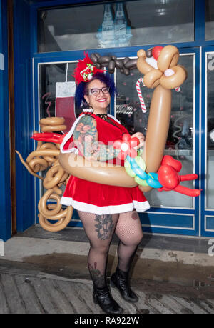 Portrait of a woman in a Santa costume with a reindeer made out of balloons at the annual Polar Bear Club New Year's day swim in Coney Island, NYC. Stock Photo