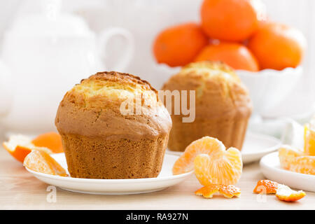 Muffin with tangerines closeup on white background. Sweet delicious homemade baking. . White background. Wooden background. Stock Photo