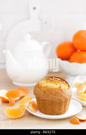 Muffin with tangerines closeup on white background. Sweet delicious homemade baking. . White background. Wooden background. Stock Photo