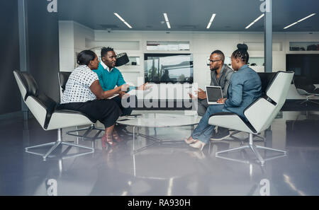 Team of african bussines people sitting in a modern office and talking during an work meeting Stock Photo