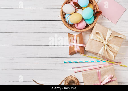 Background with easter eggs, gift boxes and decorations on white, top view with copy space Stock Photo