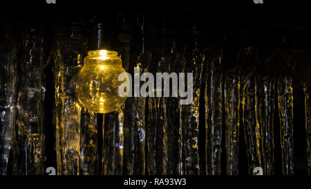 Light bulb and icicles in background Stock Photo