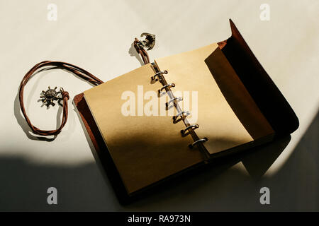vintage brown leather Notepad open clean blank sheets of paper. in the shadow. Stock Photo