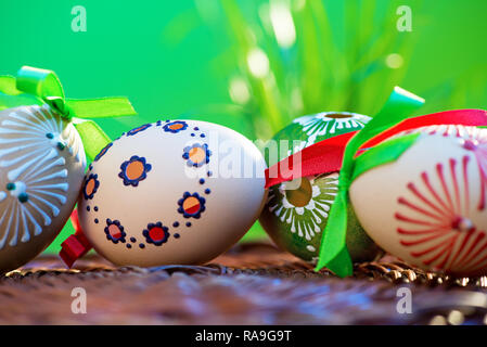 Painted easter eggs in the wicker basket in the grass. Stock Photo