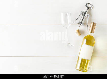 White wine bottle with corkscrew, cork and wine glass on white wooden table flat lay from above with copy space Stock Photo