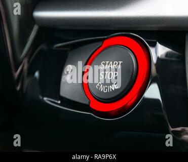 Car dashboard with focus on red engine start stop button, car interior details Stock Photo