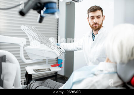 handsome dentist during the consultation with senior woman in the dental office Stock Photo