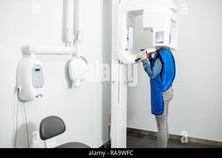 Modern cental x-ray rom with woman making panoramic shot of the jaw Stock Photo
