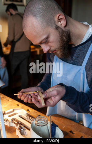 male craftsman violin maker working on a new violin in the workshop Stock Photo