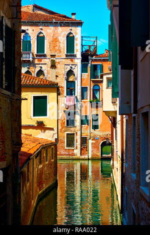 Narrow shady canal in Veinice on a sunny day, Italy Stock Photo
