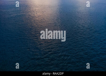 Blue sea water with soft reflection of sunset sun on calm surface. Nature background. Horizontal color photography. Stock Photo