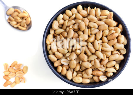 Peanuts on a Spoon. Close-up View of Peanuts in a Bowl isolated on white Background.  Closeup of healthy Peanut Kernels. Stock Photo