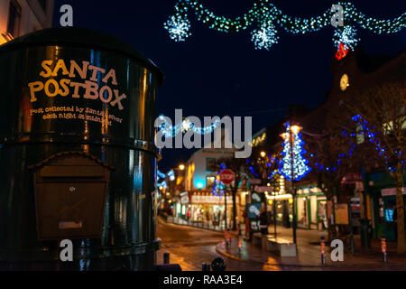 Christmas Ireland and Santa post box or mail box or letterbox and Christmas street lights during the festive celebrations in Killarney,  Ireland Stock Photo