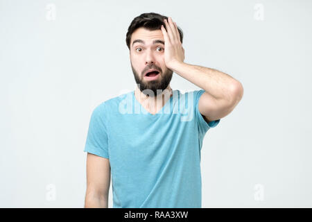 Puzzled frustrated male looks with bewilderment, reacts on sudden message Stock Photo