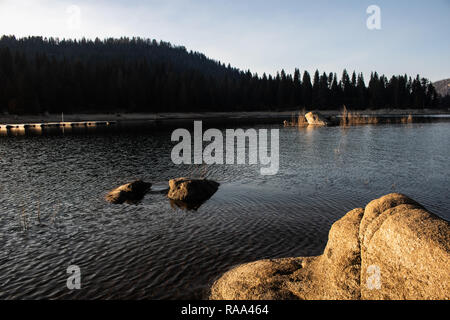 Beautiful Shaver lake in early fall. Mid afternoon sun was beating down water was perfect and cold.Water was calm yet wavy fisherman waiting to catch. Stock Photo