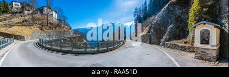 Mountain chapel on winding road with Italian Alps panorama from  Castello Italy village, small town in Pellizzano, region Trentino, Italy Stock Photo