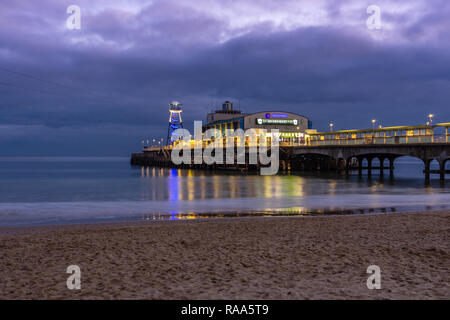 Bournemouth Pier with lights reflected at night / twilight, January 2019, Bournemouth, Dorset, England, UK Stock Photo