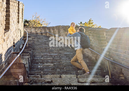 Happy cheerful joyful tourists dad and son at Great Wall of China having fun on travel smiling laughing and dancing during vacation trip in Asia. Chinese destination. Travel with children in China concept Stock Photo