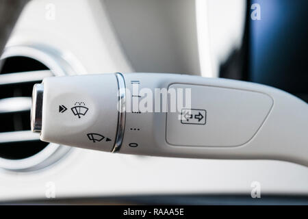 Wipers switch control. White leather Modern car interior detail. Adjusting speed of screen wipers in car. Wiper switch toggle. Automotive part concept Stock Photo
