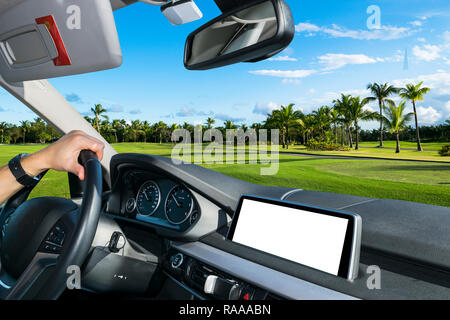 Male hands holding car steering wheel. Hands on steering wheel of a car driving near palm field. Man driving a car inside cabin. Multimedia system iso Stock Photo