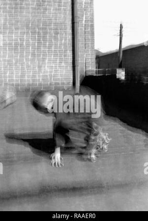 A young boy is a blur while skating on a rooftop, ca. 1925. Stock Photo