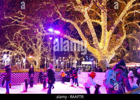 VIENNA, AUSTRIA - DEC 18, 2018: People skating at the ice rink near the Rathaus Palace near to famouse Christmas market in Wien city hall, Austria. Stock Photo