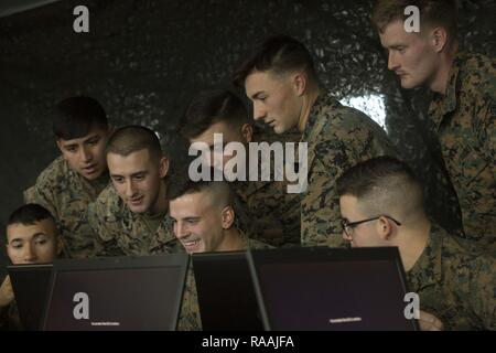 U.S. Marines with Echo Company, 2nd Battalion, 6th Marine Regiment, 2nd Marine Division (2d MARDIV), watch a fellow Marine as he competes in the Spartan Tactical Games utilizing Virtual Battlespace 3 (VBS 3) on Camp Lejeune, N.C., Jan. 10, 2017. VBS 3 and the Spartan Tactical Games allow the Marines to test their tactical and cognitive thinking while competing against each other on a squad level. Stock Photo