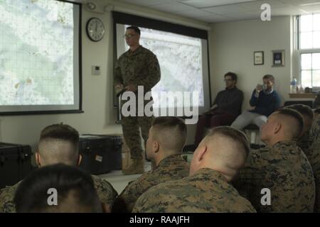 U.S. Marine Corps Sgt. Daniel A. Daly, center, a squad leader with Echo Company, 2nd Battalion, 6th Marine Regiment, 2nd Marine Division (2d MARDIV), debriefs Marines after utilizing Virtual Battlespace 3 (VBS 3) during the Spartan Tactical Games on Camp Lejeune, N.C., Jan. 10, 2017. VBS 3 and the Spartan Tactical Games allow the Marines to test their tactical and cognitive thinking while competing against each other on a squad level. Stock Photo