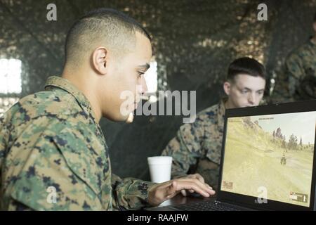 U.S. Marine Corps Lance Cpl. Angel L. Waite, left, a squad leader with Echo Company, 2nd Battalion, 6th Marine Regiment, 2nd Marine Division (2d MARDIV), utilizes Virtual Battlespace 3 (VBS 3) during the Spartan Tactical Games on Camp Lejeune, N.C., Jan. 10, 2017. VBS 3 and the Spartan Tactical Games allow the Marines to test their tactical and cognitive thinking while competing against each other on a squad level. Stock Photo