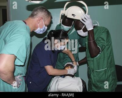 A team of U.S. military and Senegalese medical professionals examine a dental patient during Medical Readiness Training Exercise 17-1 at La Sante des Armees Hospital in Dakar, Senegal, Jan. 12, 2017. MEDRETE is a combined effort between the Senegalese government, U.S. Army Africa, the U.S. Army Reserve 332nd Medical Brigade in Nashville, Tenn., and the Vermont Air National Guard. AFRICOM’s MEDRETEs hosted by United States Army-Africa pair small teams of military medical professionals from the U.S. with participating African partner nations to train alongside and share best practices in trauma  Stock Photo