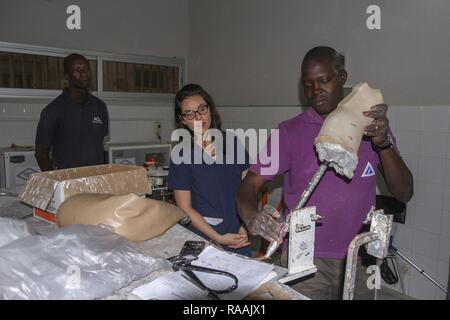 Senegalese prosthesis technician Mamadou Kare, customizes a prosthetic limb for a patient as U.S. military medical professionals observe during Medical Readiness Training Exercise 17-1 at La Sante des Armees Hospital in Dakar, Senegal, Jan. 12, 2017. MEDRETE is a combined effort between the Senegalese government, U.S. Army Africa, the U.S. Army Reserve 332nd Medical Brigade in Nashville, Tenn., and the Vermont Air National Guard. AFRICOM’s MEDRETEs hosted by United States Army-Africa pair small teams of military medical professionals from the U.S. with participating African partner nations to  Stock Photo