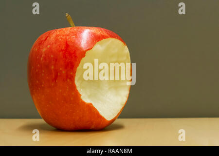 red bitten apple on green background Stock Photo