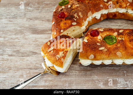 King's cake, roscon de Reyes, handmade in the oven, on a cozy wooden base, typical spanish christmas cake, Madrid, Spain. Stock Photo