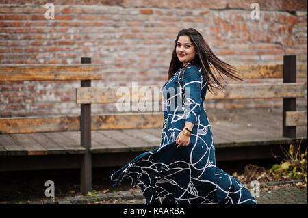 Brunette indian woman in long fashionable dress dancing outdoor. Stock Photo