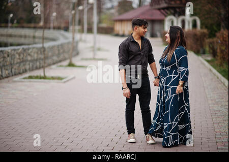 Love story of indian couple posed outdoor, sitting on bench together ...