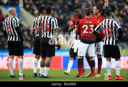 Manchester United's Paul Pogba (centre) exchanges words with Newcastle United's Jonjo Shelvey after a foul during the Premier League match at St James' Park, Newcastle. Stock Photo