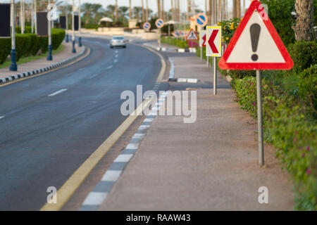 Warning sign on an urban street with an exclamation mark in a triangle cautioning of a bend in the road ahead Stock Photo