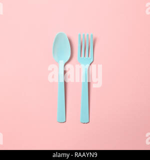 Blue plastic fork and spoon isolated on pink background Stock Photo