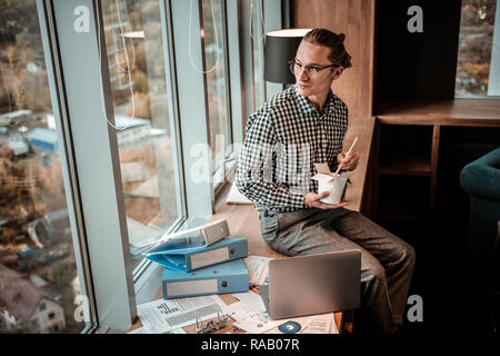 Relaxed young man enjoying his Chinese food Stock Photo