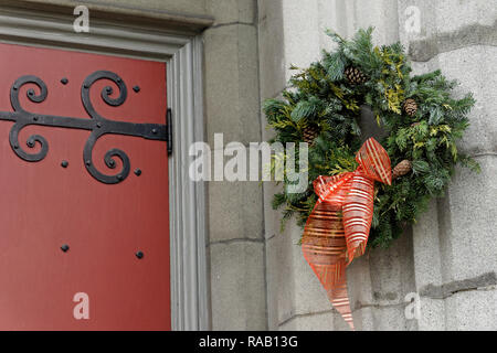 Traditional natural green Christmas wreath hanging next to the door of a church Stock Photo
