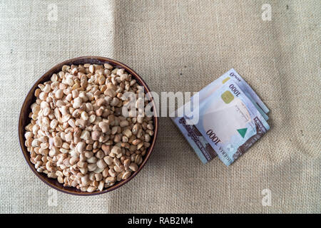 Bowl of beans with Nigerian Naira to purchase Stock Photo