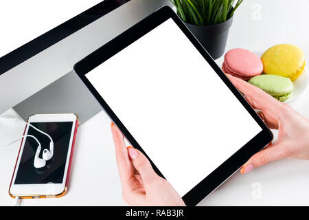 Woman hands holding and using tablet computer with isolated white screen. Business workplace with computer and wireless mouse and keyboard. Blank empt Stock Photo