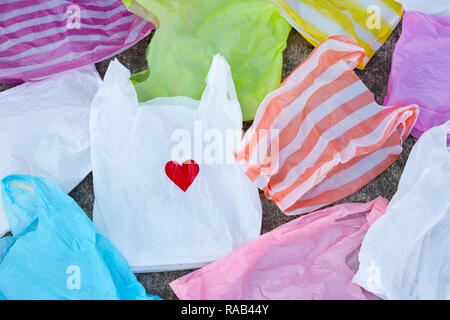 Colorful plastic bags on cement floor background Stock Photo