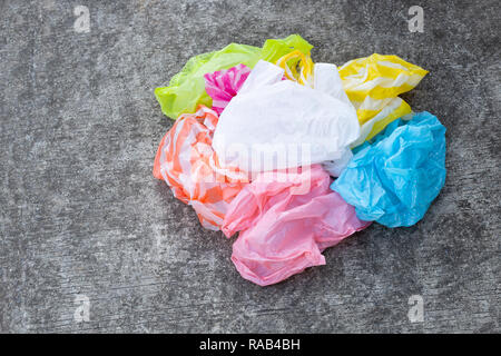 Colorful plastic bags on cement floor background. Stock Photo