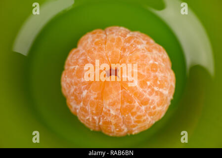 Peeled tangerine without peel on a green background isolated Stock Photo