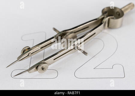 A companion for drawing circles on a white piece of paper. Drafting accessories for drawing technical drawings. Light background. Stock Photo