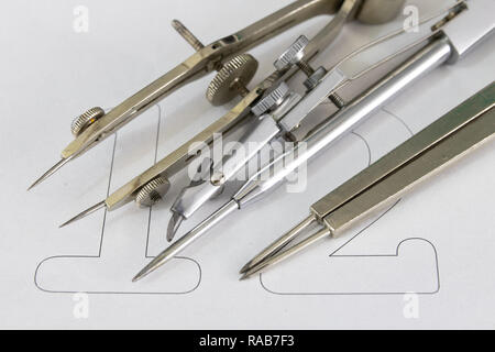A companion for drawing circles on a white piece of paper. Drafting accessories for drawing technical drawings. Light background. Stock Photo